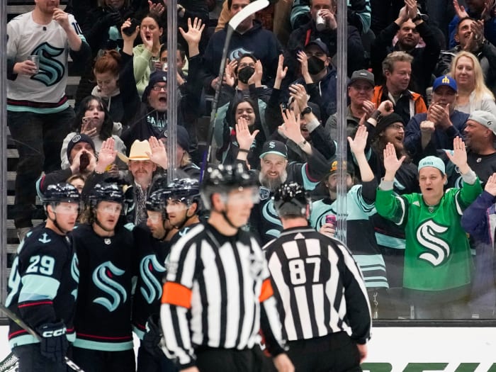 Seattle Kraken fans pound the glass as they celebrate a goal by right wing Jordan Eberle against the Arizona Coyotes.
